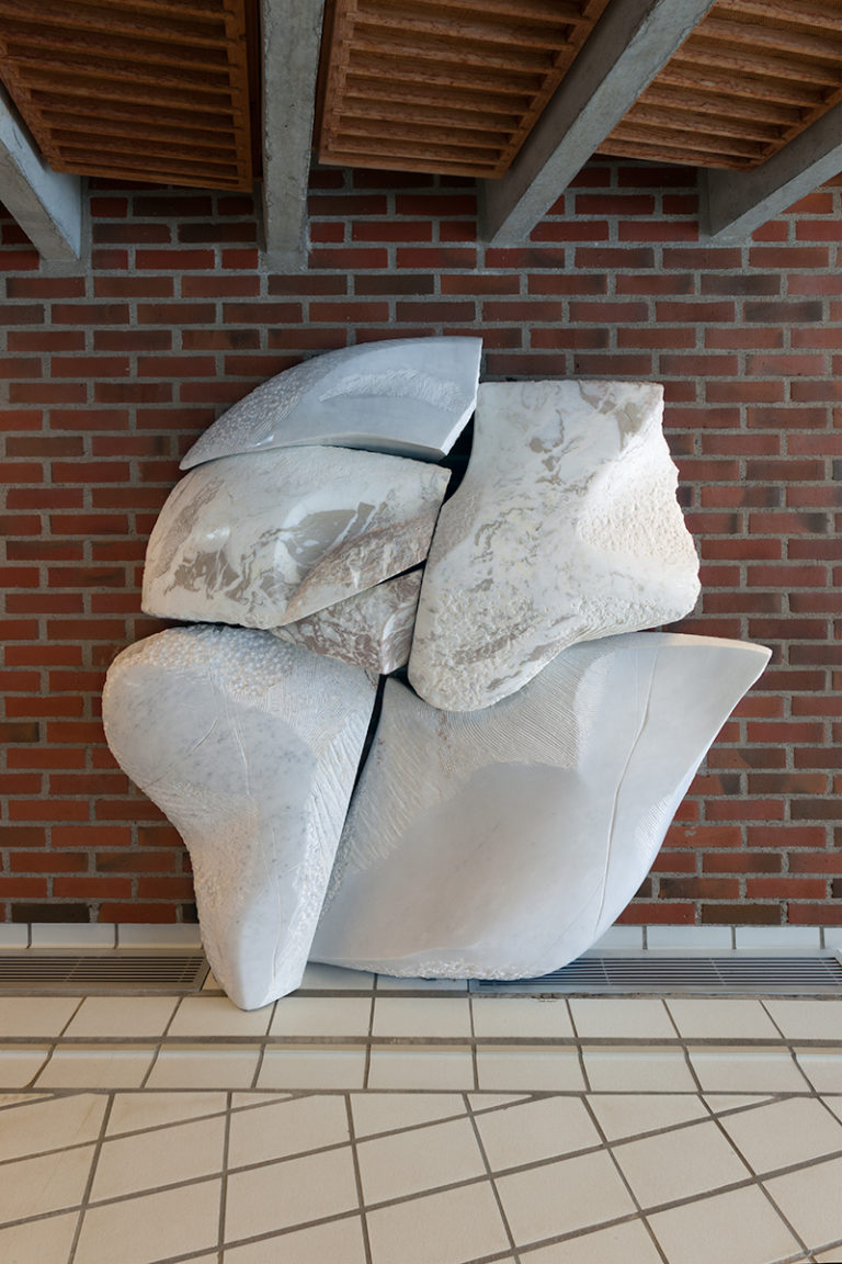 A marble relief by Inger Sitter, which was made originally for the swimming pool at Skådalen School for Deaf and Hearing-Impaired Children, has moved with the school to its new premises. The pale marble, with its many different textures and gently undulating surface, leads one’s thoughts to rocky outcrops and stones. These were recurring themes in Sitter’s motifs. The new location for the work in the stairwell was chosen as a place where it can be touched by passing children and young people in recognition of the tactile nature of the work.