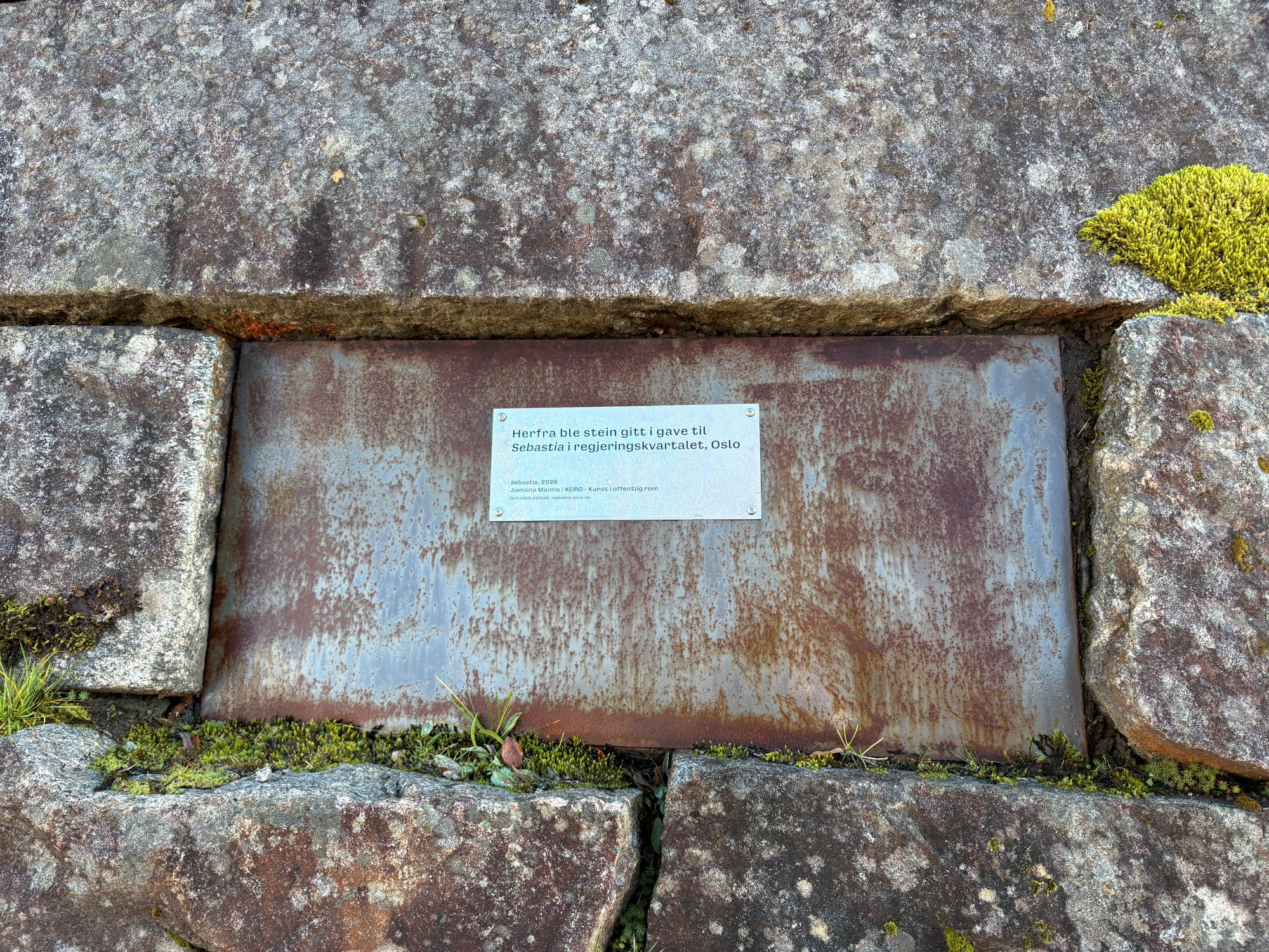 Ein plakett har vorte send til alle som har bidrege med stein til regjeringskvartalet. Her ser me donasjonen frå Namsos kommune i Trøndelag som har sett opp plaketten på kyrkjemuren, der deira donerte steinen kjem frå.